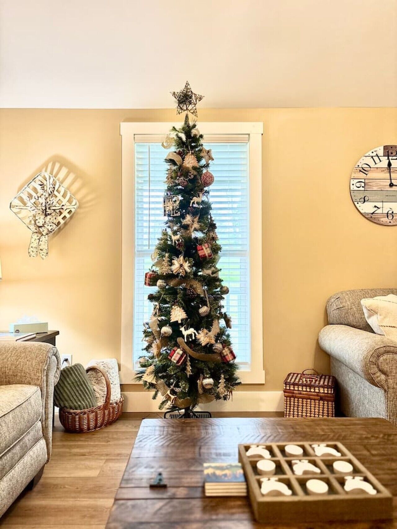 Un salon avec un sapin de Noël, une horloge et une cheminée.