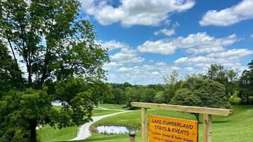 Cartel de Lake Cumberland Stays & Events en un área con césped y cielo despejado.