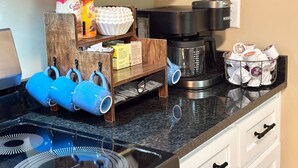Une cuisine équipée d’une machine à café, d’une bouilloire et d’un compartiment pour ranger les grains de café.