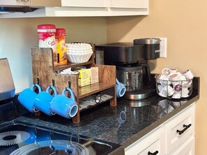 Eine Küche mit Kaffeemaschine, Wasserkocher und einer Kaffeebohnen-Aufbewahrung.