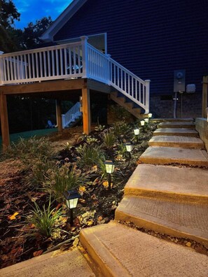 Une terrasse en bois dotée d’une rambarde, qui mène à un escalier.