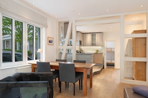 Una cocina moderna con electrodomésticos integrados y un comedor con mesa y sillas de madera.
