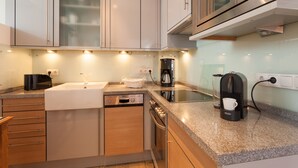 Uma cozinha moderna com máquina de lavar louça Bosch, cafeteira e torradeira.