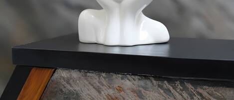 A white ceramic vase with a floral design on a black surface.