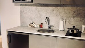 A compact kitchen with a stainless steel sink, a built-in dishwasher, and a small countertop. - Palazzina B  (Genoa)
