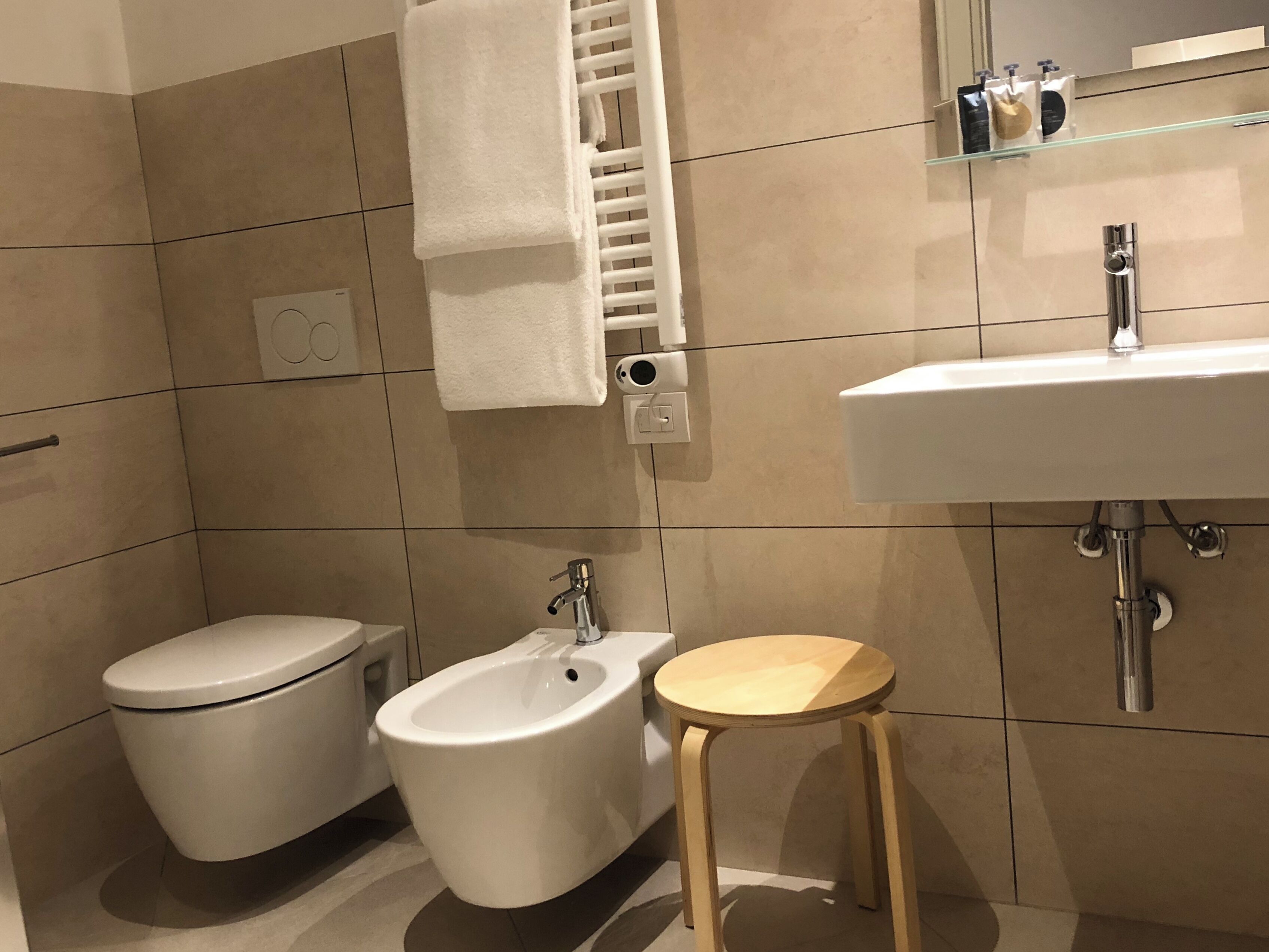 A modern bathroom with a toilet, bidet, and sink.