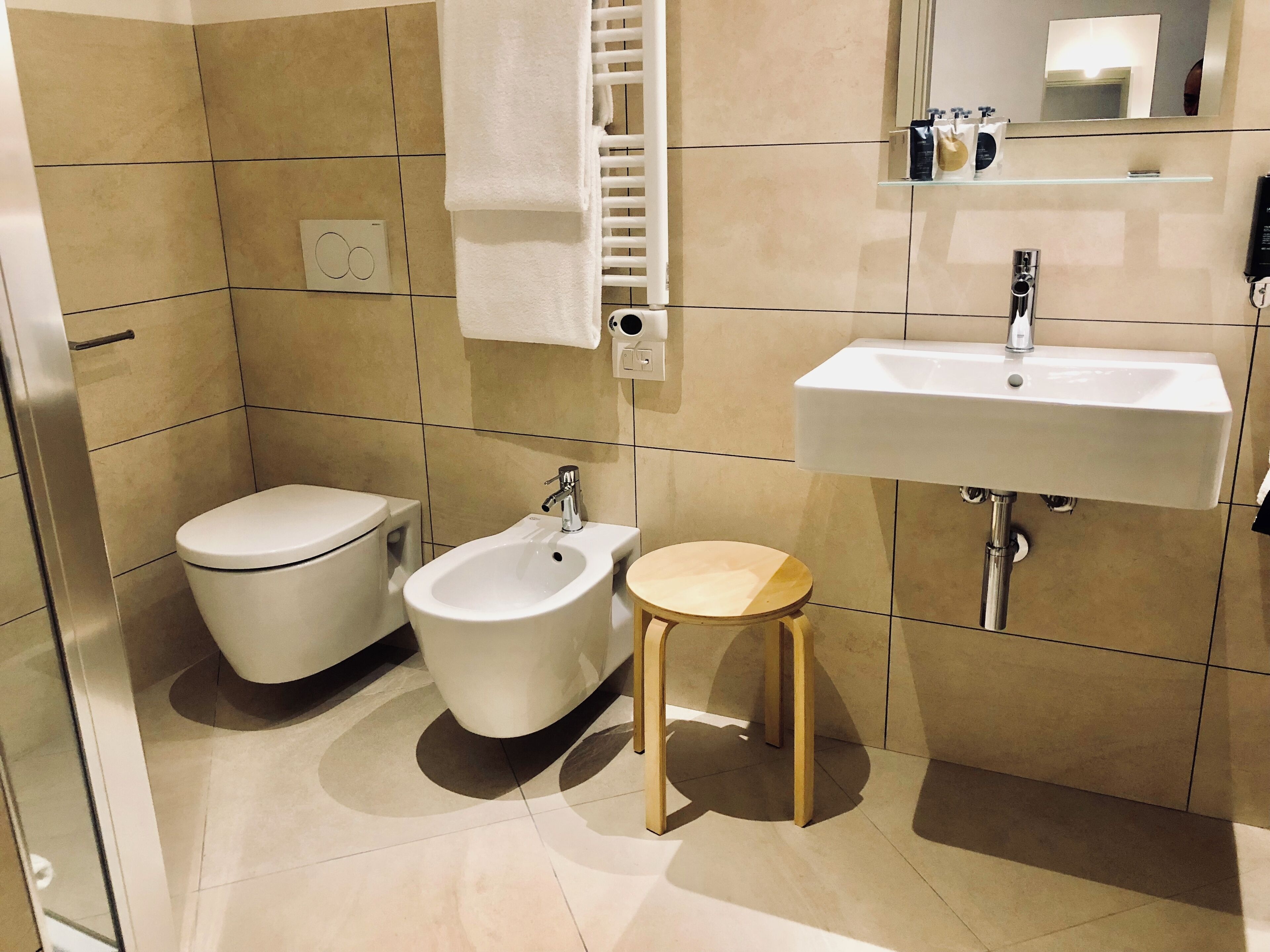 Egy modern fürőszoba, amelyben WC, bidé és mosdókagyló található.