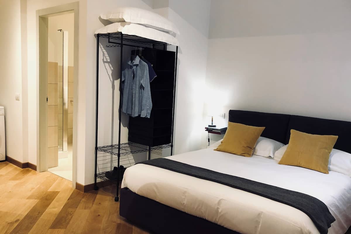 A bedroom with a bed, a wardrobe, and a nightstand.
