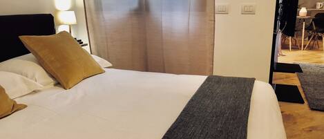A bed with white and brown pillows, a grey blanket, and a wooden headboard.