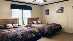 A bedroom with two beds, a ceiling fan, a window with blinds, and a wall with two framed pictures. - Lake front hideaway with spectacular views. (Hemphill)