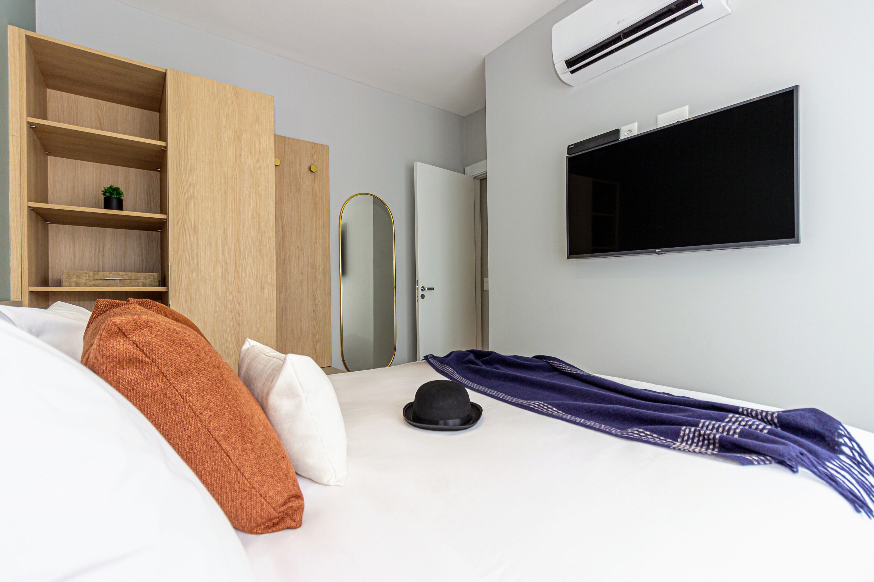 Habitació d'hotel amb un llit, un armari, una televisió i una porta.