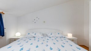 A bedroom with a bed, two bedside tables, a wall with star decorations, and a blue curtain. - Apartman Seaside 067 by Villas Guide (Pula)