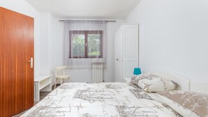 A bedroom with a bed, a chair, a desk, and a window with a curtain. - Apartman Seaside 064 by Villas Guide (Pula)