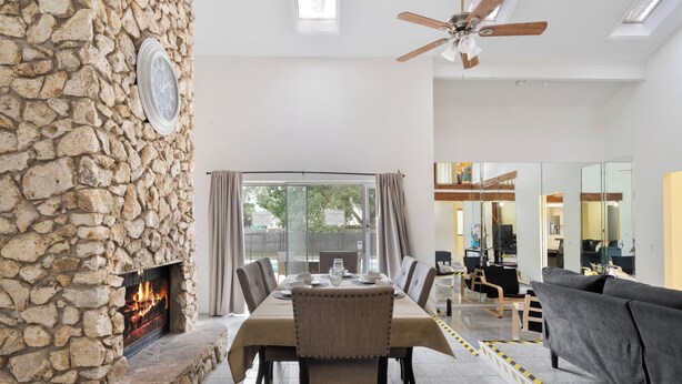 A dining area with a stone wall, a fireplace, and a view of the outdoors. - Pleasant and RUSTIC 4-bedroom house in the heart of Orlando (Orlando)
