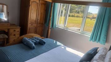 Ein Schlafzimmer mit einem Bett, einem Holzschrank und einem Fenster mit Vorhängen.