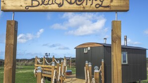 A wooden archway with the word "Blackberry" and a small cabin with a chimney and a window.