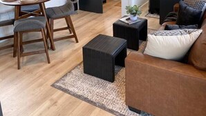 Un salon moderne comprenant un coin repas, un téléviseur fixé au mur et une porte coulissante donnant accès à une salle de bain.