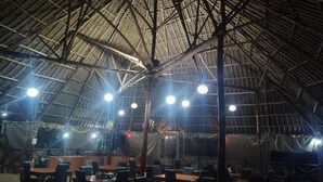An indoor venue with a high, thatched roof and multiple tables and chairs arranged for dining. - Eco Deluxe Double at Tausa Tsavo Lodge - 2341 (Voi)