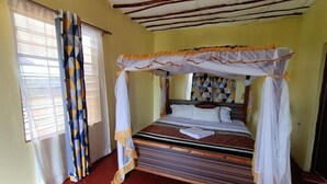 A single bed with a canopy, a window with curtains, and a red floor. - Eco Deluxe Double at Tausa Tsavo Lodge - 2341 (Voi)