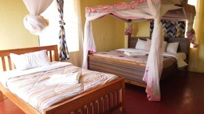 A room with a wooden bed, a smaller bed with a canopy, and a window with curtains. - Eco Deluxe Double at Tausa Tsavo Lodge - 2341 (Voi)
