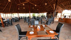 An outdoor dining area with tables and chairs, a thatched roof, and a sign reading "CHEF'S PLACE". - Eco Deluxe Double at Tausa Tsavo Lodge - 2341 (Voi)