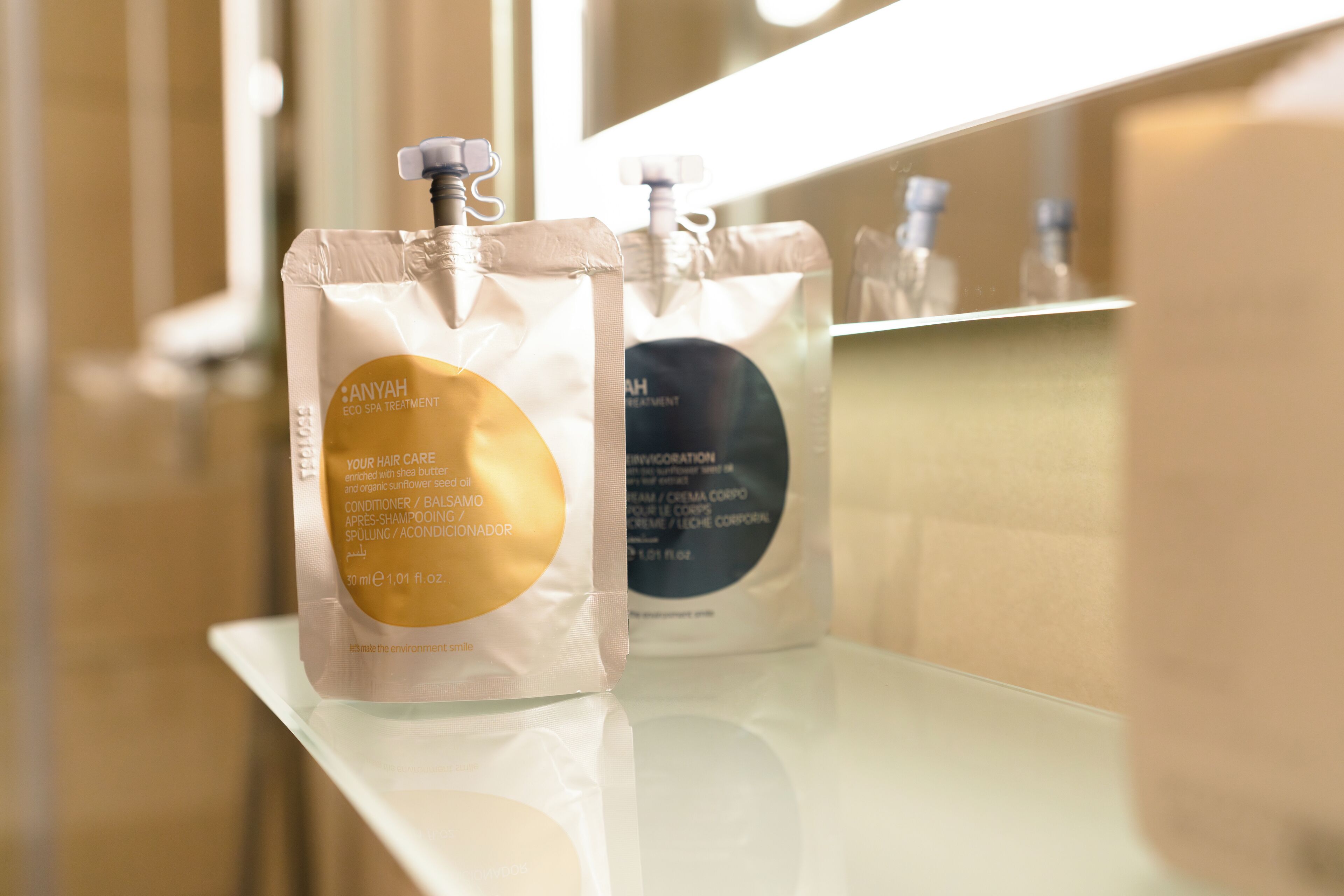 Two bottles of Anyah eco spa treatment on a reflective surface.