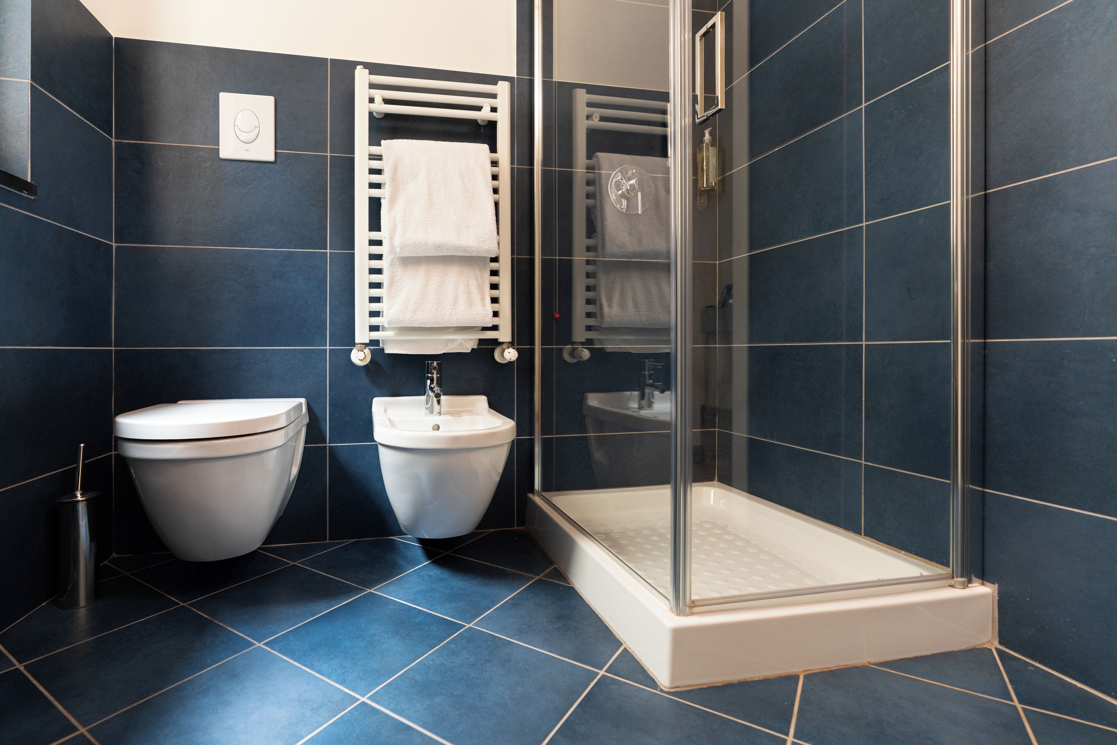 Een moderne badkamer met toilet, bidet en douchecabine.