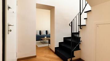Un intérieur moderne avec un escalier, un canapé et une table basse.