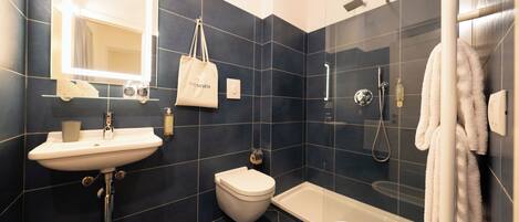 A modern bathroom with a sink, toilet, bathtub, and a glass-enclosed shower.