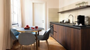 Una cucina compatta con zona pranzo, mobili in legno e macchina da caffè.