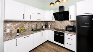 A modern kitchen with white cabinets, a black refrigerator, a microwave, and a built-in oven. - Villa Stavroula - Two Bedroom Villa, Sleeps 4 (Mparmpati)