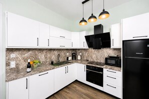 A modern kitchen with white cabinets, a black refrigerator, a microwave, and a built-in oven. - Villa Stavroula - Two Bedroom Villa, Sleeps 4 (Mparmpati)