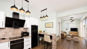A modern kitchen with a marble countertop, black appliances, and pendant lighting. - Villa Stavroula - Two Bedroom Villa, Sleeps 4 (Mparmpati)