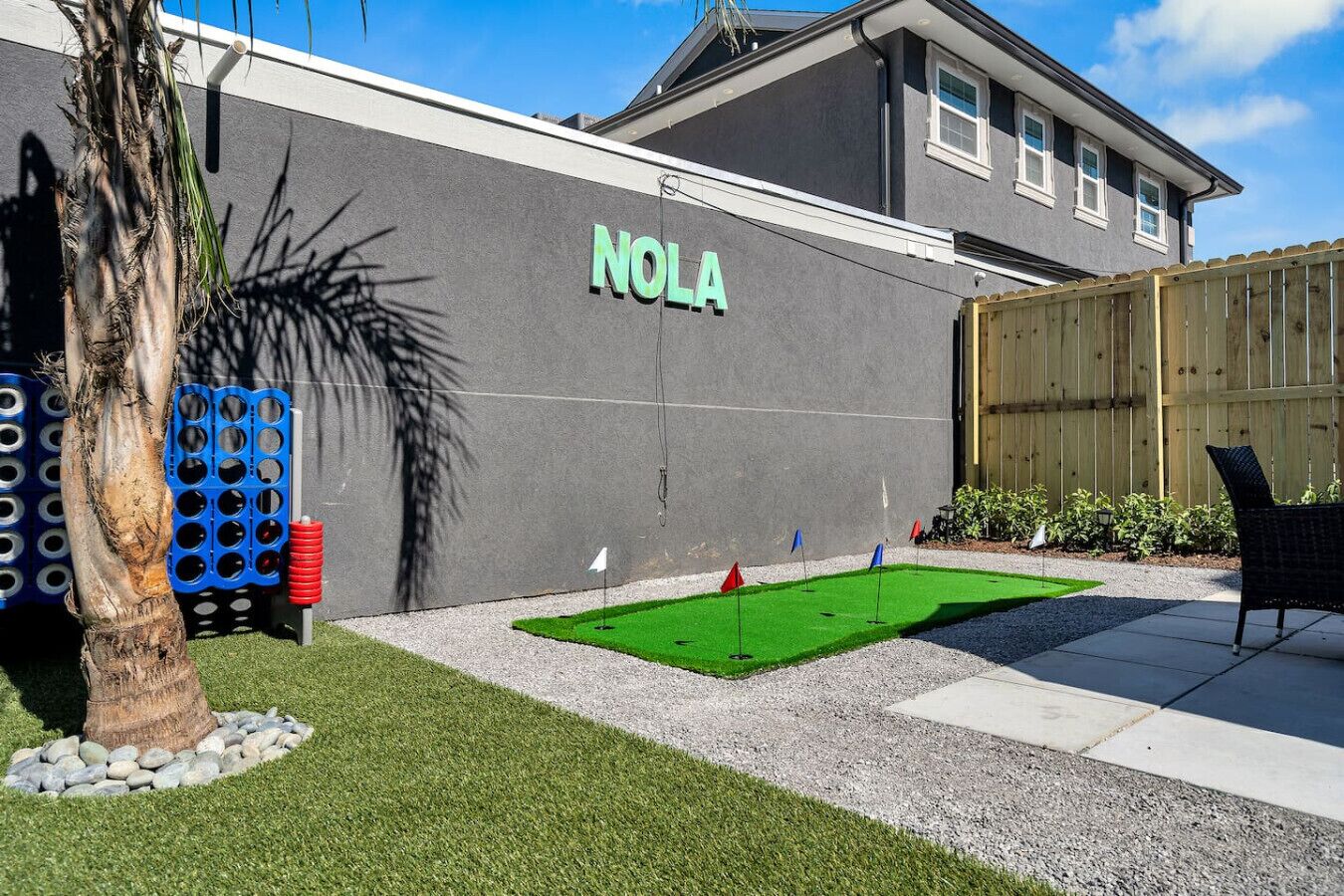 Ein Gebäude mit einem Schild, auf dem "NOLA" steht, und einem kleinen, künstlichen Golfplatz davor.