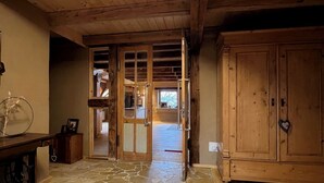Ein Holzinnenraum mit Steinboden, einem Holzkabinett und einer Tür zu einem anderen Raum.