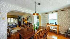 A dining area with a wooden table, chairs, and a hanging light fixture. - DV-627 Walk to Breweries! Pets OK! (Davis)