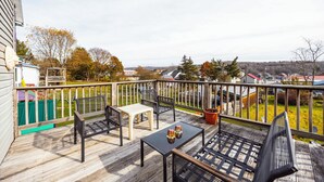 A wooden deck with outdoor furniture, including a bench and a table, overlooking a residential area with houses and trees. - DV-627 Walk to Breweries! Pets OK! (Davis)