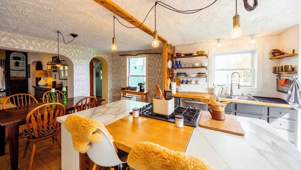 A modern kitchen with wooden beams, a marble countertop, and a dining area with wooden chairs. - DV-627 Walk to Breweries! Pets OK! (Davis)
