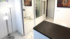 Een moderne badkamer met een marmeren vloer, een zwarte aanrecht en een douchecabine van glas.