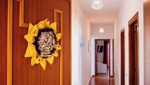 A hallway with a wooden door featuring a yellow and gray decorative wreath with a 'Welcome' sign. - VILLA HEMINGWAY - ALESSIA'S HOUSE BREATHTAKING SEA VIEW (Ficarazzi)