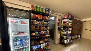 Un supermercado con estantes llenos de diversos productos, como aperitivos, bebidas y alimentos envasados.