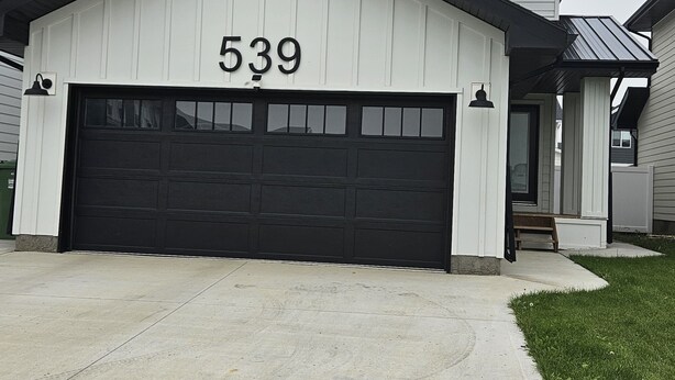 Et hus med garage nummereret 539, indkørsel og en velholdt græsplæne.