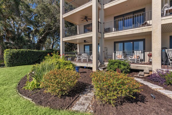A multi-story building with balconies, outdoor seating, and a landscaped garden. - Ocean Front Escape sleeps 4 (St Simons Island)