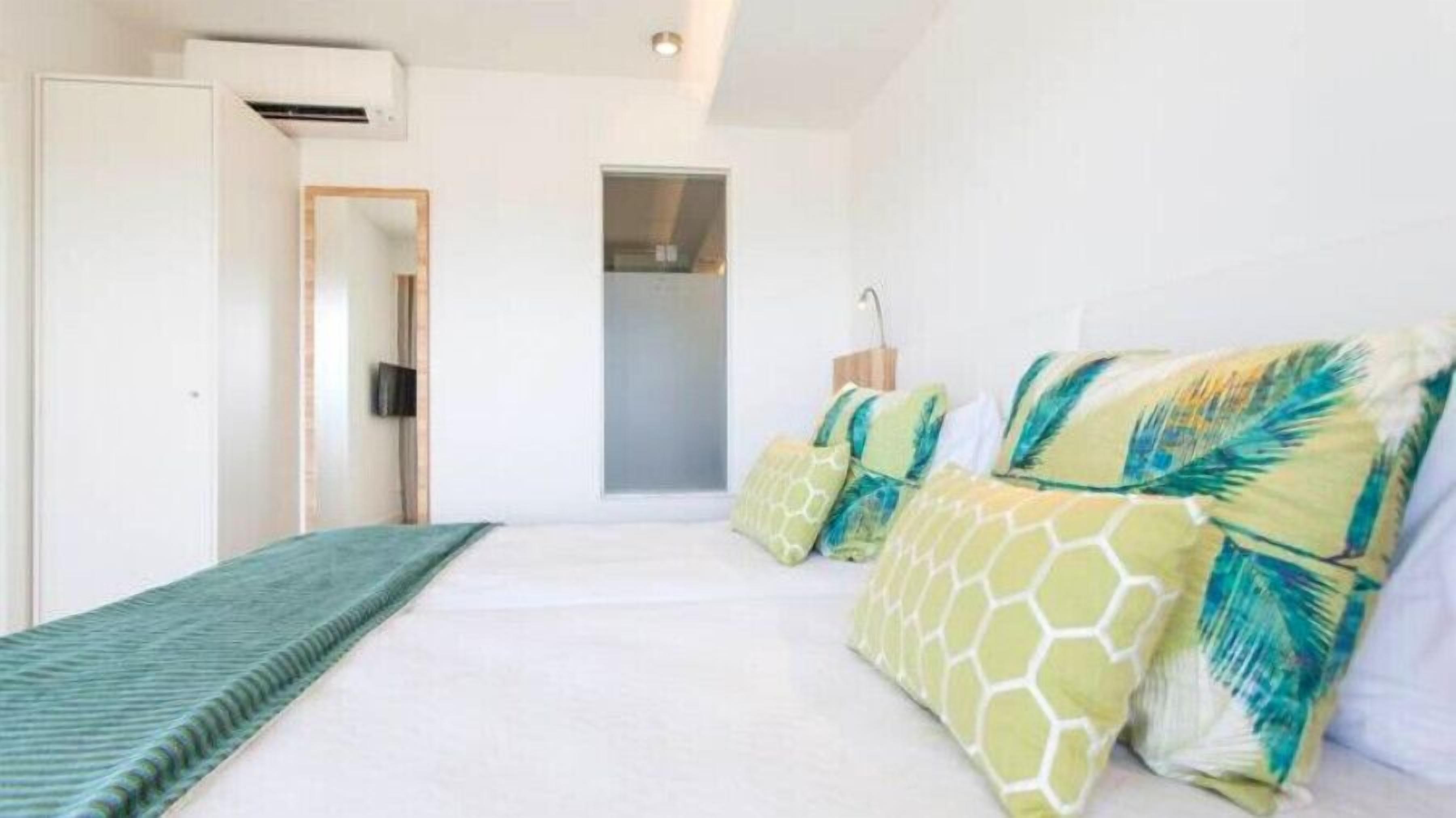A bedroom with a bed, a TV, and a door.