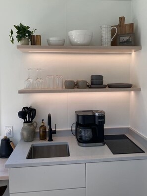 Frigorífico, placa de cocina, cafetera o tetera y utensilios de cocina