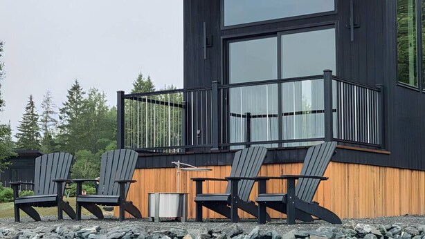 A modern building with a balcony and outdoor seating area. - Glamping Cabin | Best Bay Views | Near Restaurants (Gouldsboro)