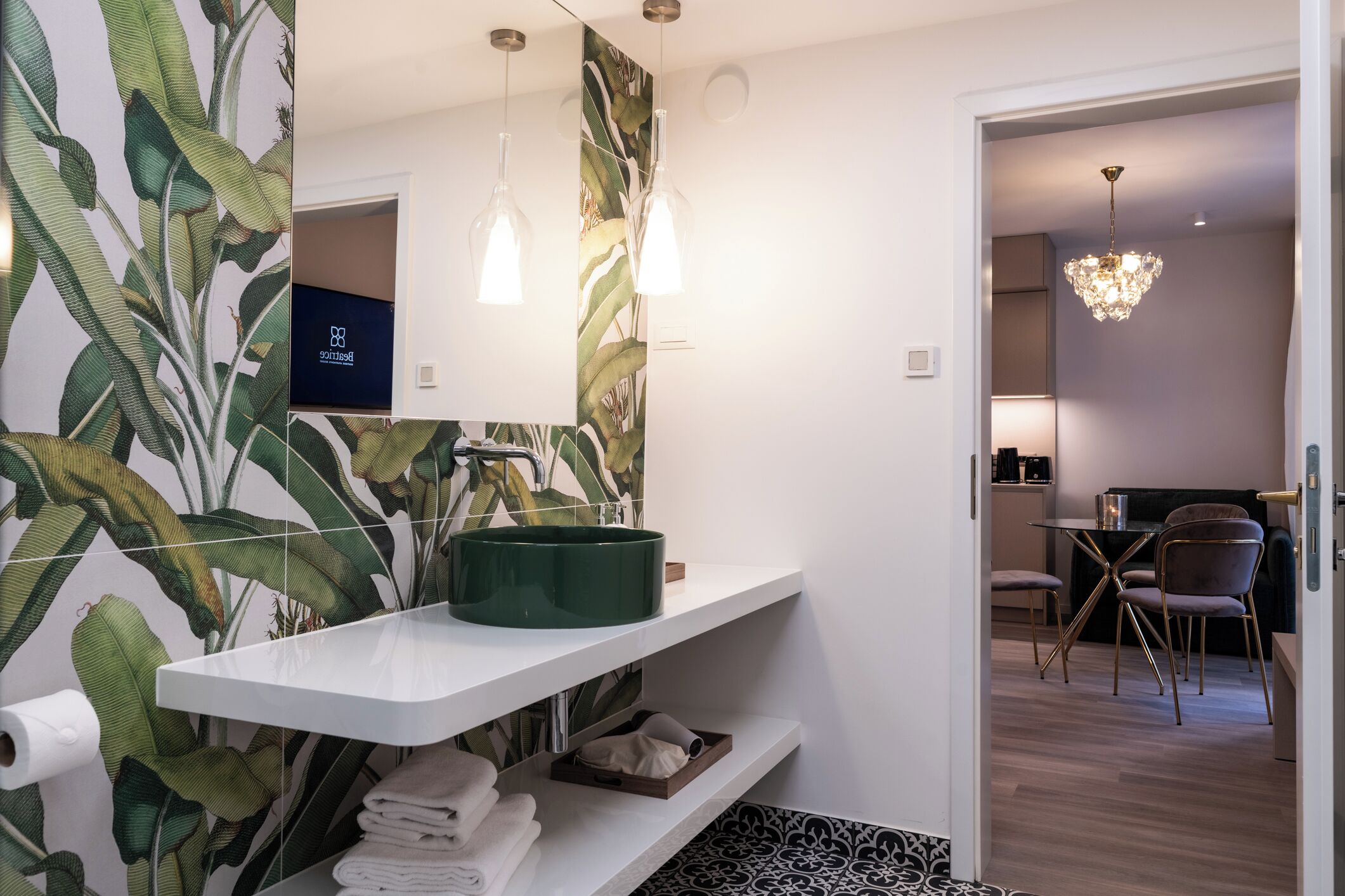 Un baño moderno con un lavabo verde, estantes blancos, un dispensador de papel higiénico y una zona de ducha.