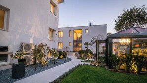 Un edificio moderno con patio, asientos al aire libre y estructura de vidrio.