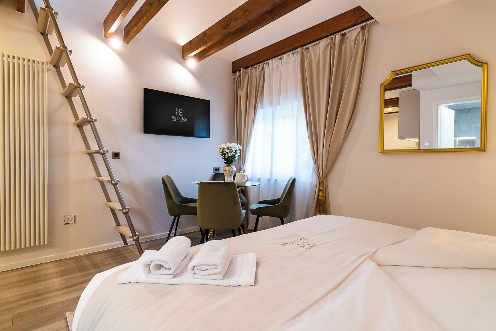 A hotel room with a bed, a desk, a chair, a TV, and a mirror.