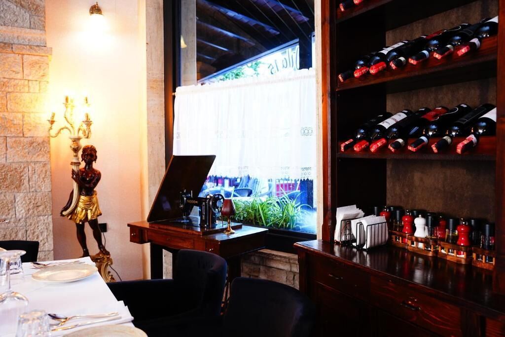 A restaurant interior with a wine rack, a statue, and a piano.